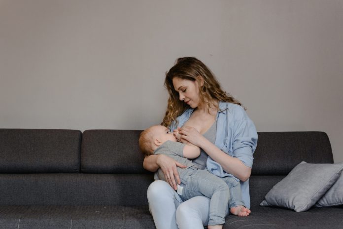 a women breast feeding her chlid in her arms